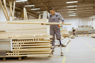 Worker with prosthetic leg in a lumber yard.